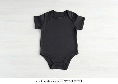 Black Baby Onesie Bodysuit Mockup For Design Presentation, Minimal Template On White Wooden Background.