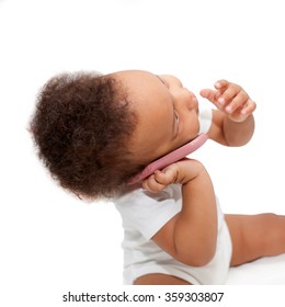 Black baby talking and playing with mobile phone. Isolated on white background