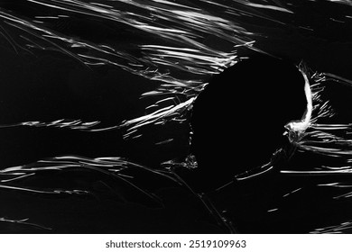 Black background, ripped plastic frame. Plain dark black background, simple desktop background with plastic texture. Cool pitch black wallpaper background. Plastic sheet overlay on black backdrop.