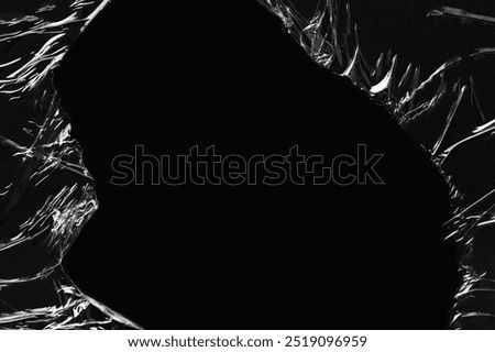 Black background, ripped plastic frame. Plain dark black background, simple desktop background with plastic texture. Cool pitch black wallpaper background. Plastic sheet overlay on black backdrop.