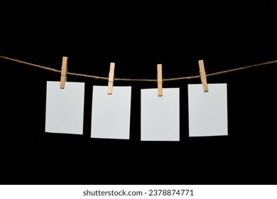 black background with a rope and clothespins holding papers