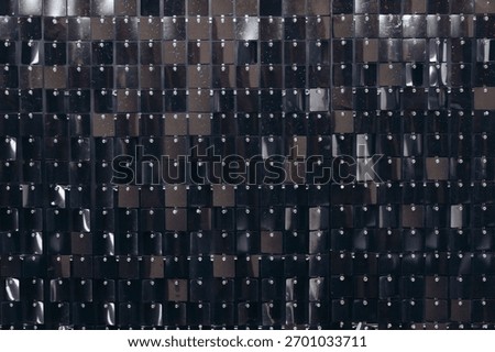 Black background of square shiny sequins
