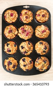 Black Baking Sheet With Blueberry And Raspberry Cupcakes, Top View.