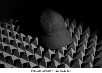 Black baseball cap mockup template  on a black soundproof foam background and deep shadows, real photo. Blank isolated to place your design. 