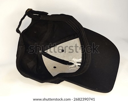 Black baseball cap turned inside, showing stitched panels and inner design, casual fashion accessory on plain background.