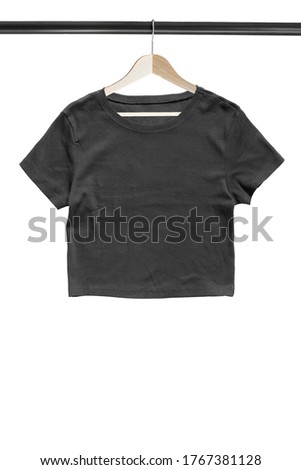 Black basic crop top hanging on wooden clothes rack isolated over white
