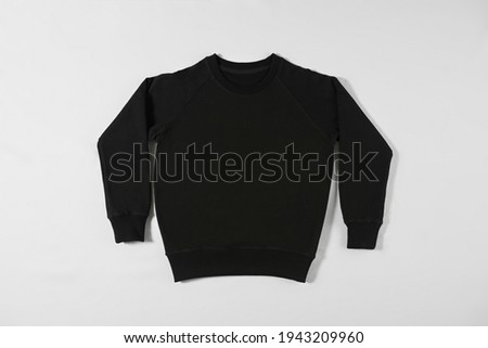 Black basic sweatshirt on light background. Casual clothes, fashion and style concept