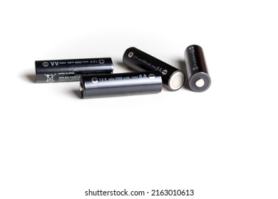 Black batteries scattered on a white background