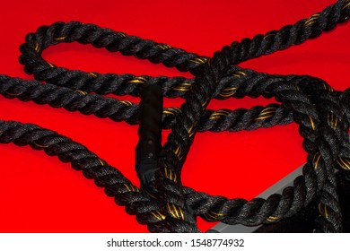 Black Battle Rope After Training In Gym, Battle Rope On Red Fitness Floor After Workout Without People