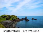 Black beach or cliff from Volcanic rocks with blue sky and ocean at seopjikoji cape, Jeju island, South korea.