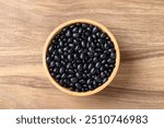 Black bean in bowl on wooden background, Table top view