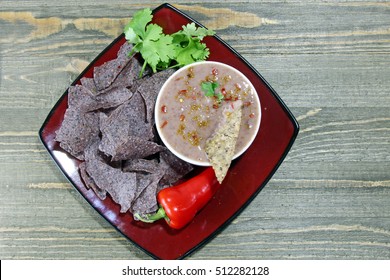 Black Bean Dip With Purple Chips And Peppers With Copy Space.