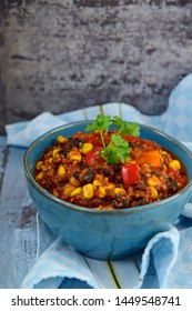 Black bean, quinoa, sweet potato, bell pepper and corn chili in a bowl garnish with parsley