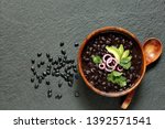  black bean soup or stew. Latin American or Mexican cuisine. stewed black beans served with avocado and red onion and cilantro. place for text. top view.