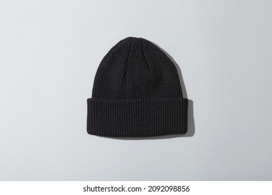 A Black Beanie With A White Background