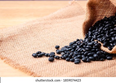 Black Beans  From Bag Spilled On A Wooden Table, Close-up And Macro Shot, Organic Food From Nature Concept.