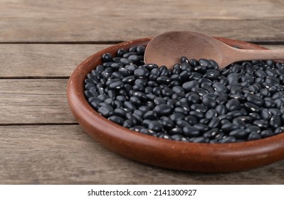 Black Beans In A Plate Over Wooden Table. Short Depth Of Field.