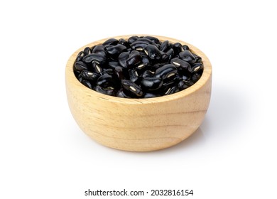 Black beans (Urad dal, black gram, vigna mungo bean) in wooden bowl isolated on white background. Clipping path.