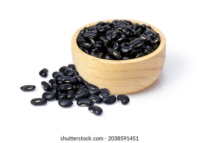 Black beans (Urad dal, black gram, vigna mungo bean) in wooden bowl isolated on white background.