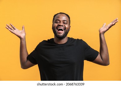 Black Bearded Man Looking Upward While Posing With Hands Up Isolated Over Yellow Background