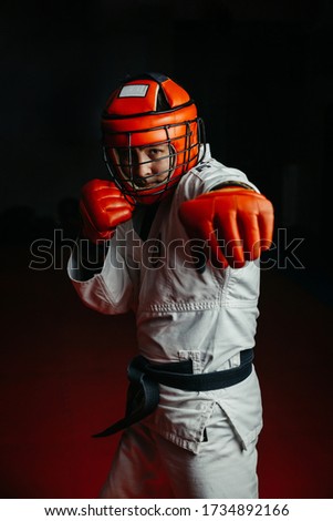 Black belt hand-to-hand combat trainer practices the attack technique while wearing gloves.
