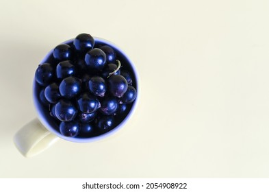 Black berry in a yellow mug on a light background top view. - Shutterstock ID 2054908922