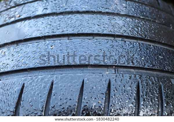 Black big tires in a close up view
with water drops. Tire tread problems. Solutions
concept.