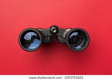 Black binoculars on color background. Top view