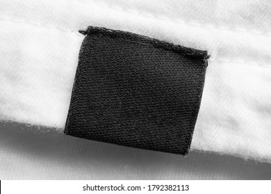 Black Blank Laundry Care Clothes Label On White Cotton Shirt Background