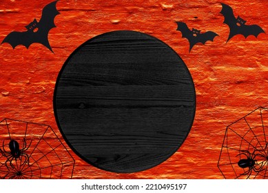 Black Blank Round Wood Sign With Copy Space Lies On Orange Background. Halloween Mockup Door Circle Sign.