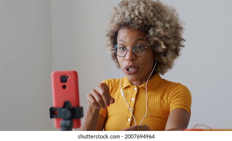 Black blogger woman recording video for social networks with a mobile phone while explaining. Content creator, influencer, streaming	