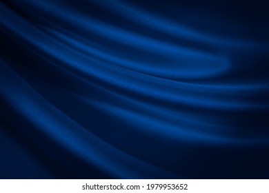  Black blue abstract background. Dark blue silk satin texture background. Shiny fabric with wavy soft pleats. Dark blue elegant background with copy space for your design. Liquid wave effect.         