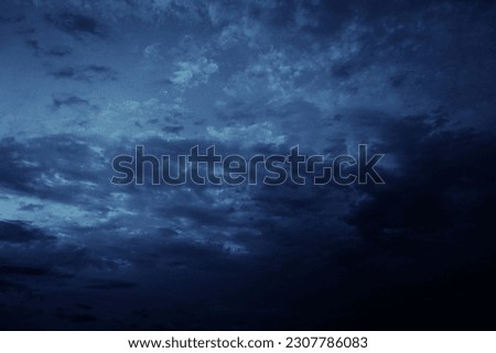 Black blue evening night sky with clouds. Dark dramatic sky background. Before the storm, thunderstorm, rain. Frightening, ominous, moody, creepy atmosphere.