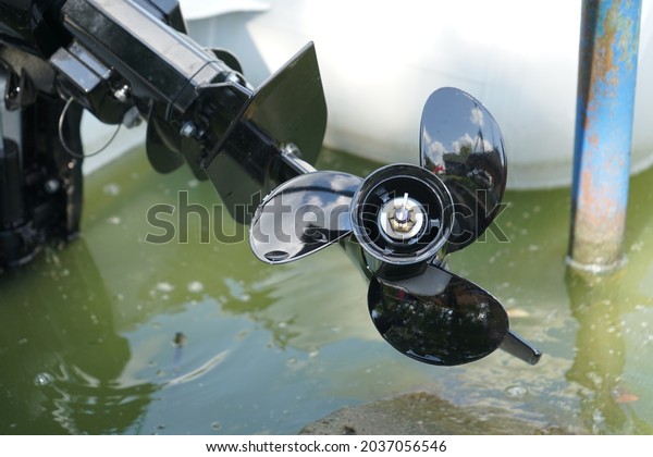 Black boat propeller in the\
water