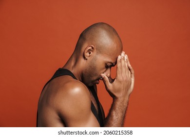 Black Bold Man With Headache Rubbing His Forehead Isolated Over Brown Background