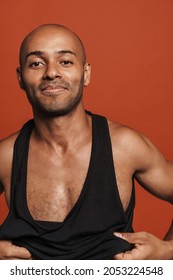 Black Bold Man Smiling While Wearing Black Shirt Isolated Over Brown Background