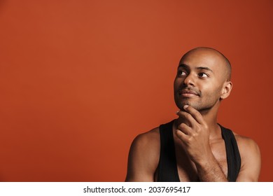 Black Bold Man Wearing Shirt Posing And Looking Aside Isolated Over Brown Background