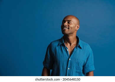 Black Bold Man Wearing Shirt Smiling And Looking Aside Isolated Over Blue Background