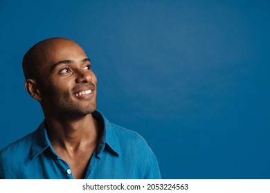 Black Bold Man Wearing Shirt Smiling And Looking Aside Isolated Over Blue Background