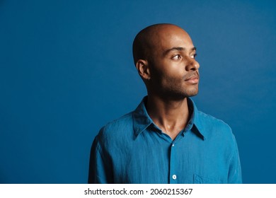 Black Bold Man Wearing Shirt Posing And Looking Aside Isolated Over Blue Background