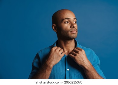 Black Bold Man Wearing Shirt Posing And Looking Aside Isolated Over Blue Background