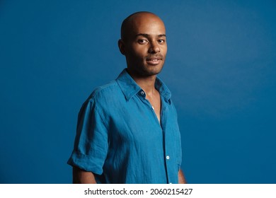 Black Bold Man Wearing Shirt Posing And Looking At Camera Isolated Over Blue Background