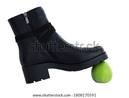 Black boot and green apple, isolate.
