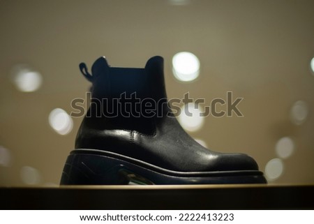 Black boot on windscreen. Shoes in store. Sale of women's shoes. Leather product.
