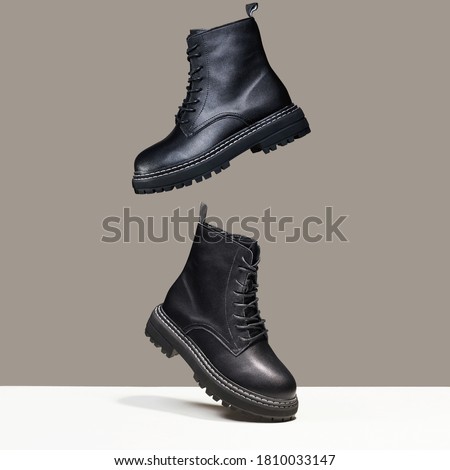 Black boots in the air. fashion shoes still life. stylish photo in the studio