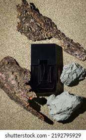 Black Bottle Of Men's Cologne On A Sand Background. Men's Perfumery