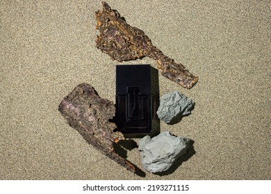 Black Bottle Of Men's Cologne On A Sand Background. Men's Perfumery