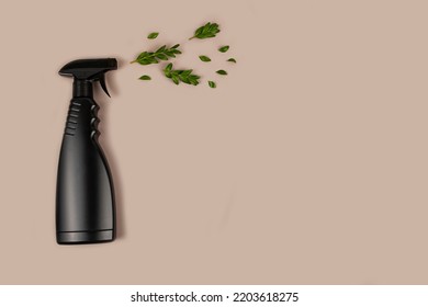 Black Bottle Mockup For Cleaning. Eco Spray Bottle For Safe Cleaning With Green Leaves On Pastel Brown Background. Copy Space, Flat Lay.