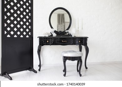 Black Boudoir Table In A Bright Room With A White Brick Wall.