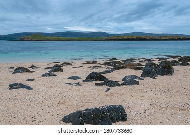 Black boulders on white beach, Coral Beach, Isle of Skye, Scotland. Concept: famous natural landscape, Scottish landscape, tranquility and serenity, seascape